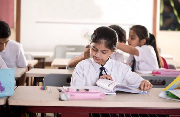 Group of students studying book at classroom